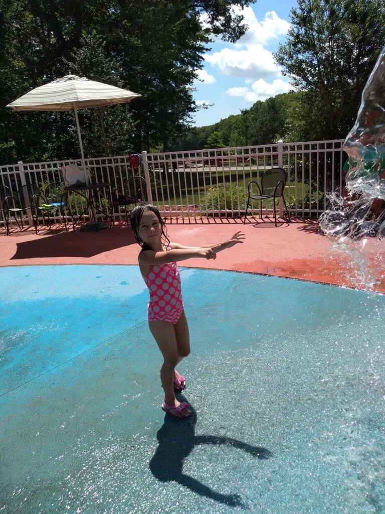 image of child play at splash pad at the dinosaur place in Montville, ct.