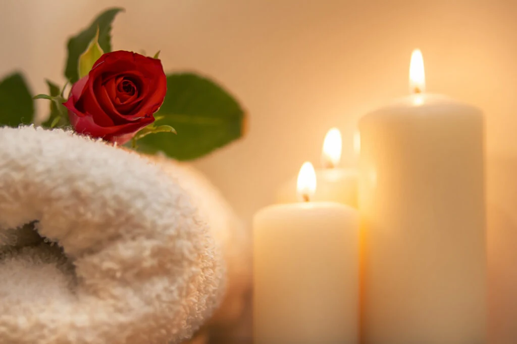 image of candles and a rose on a towel.