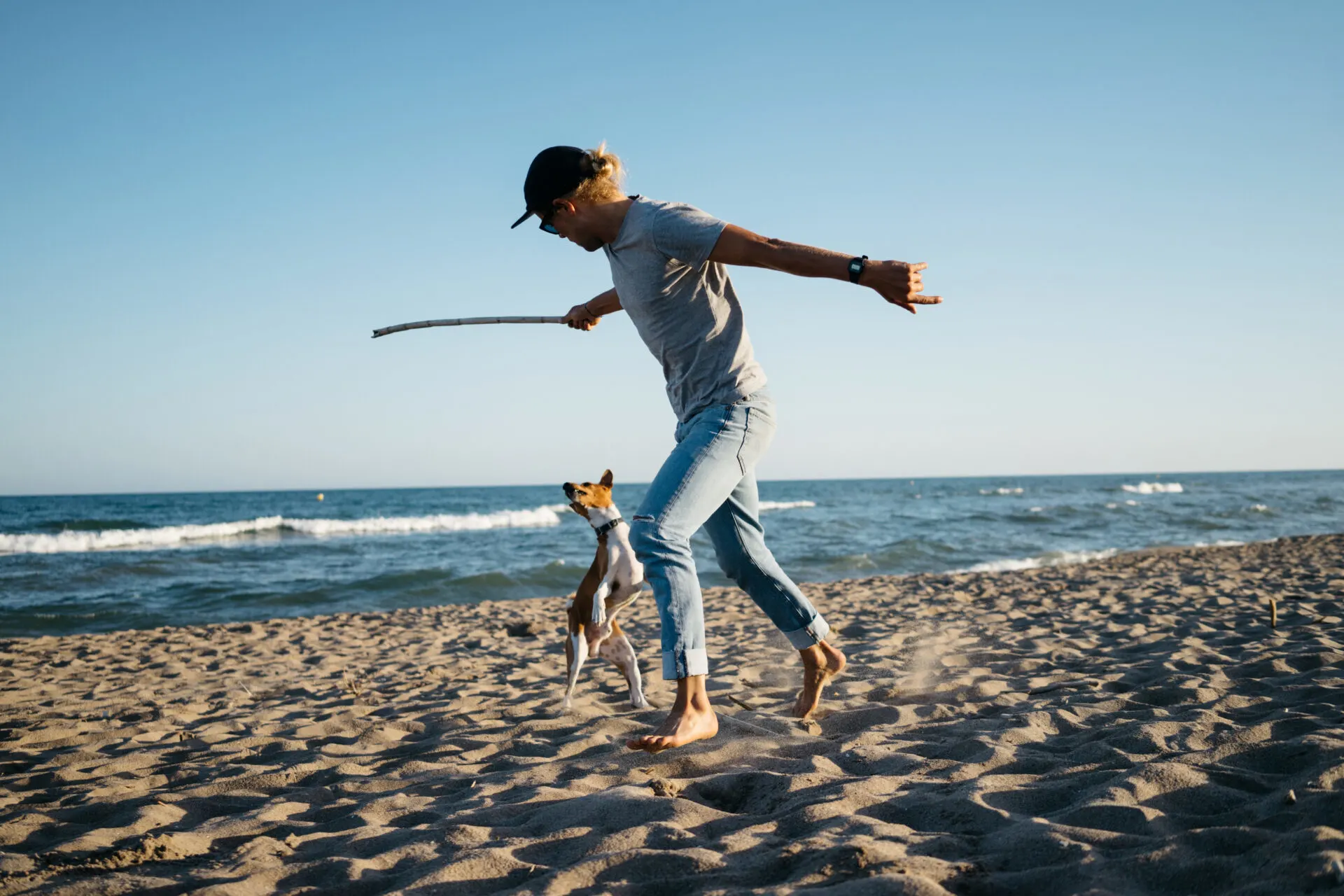 image of man playing with dog at dog-friendly beaches in Connecticut.