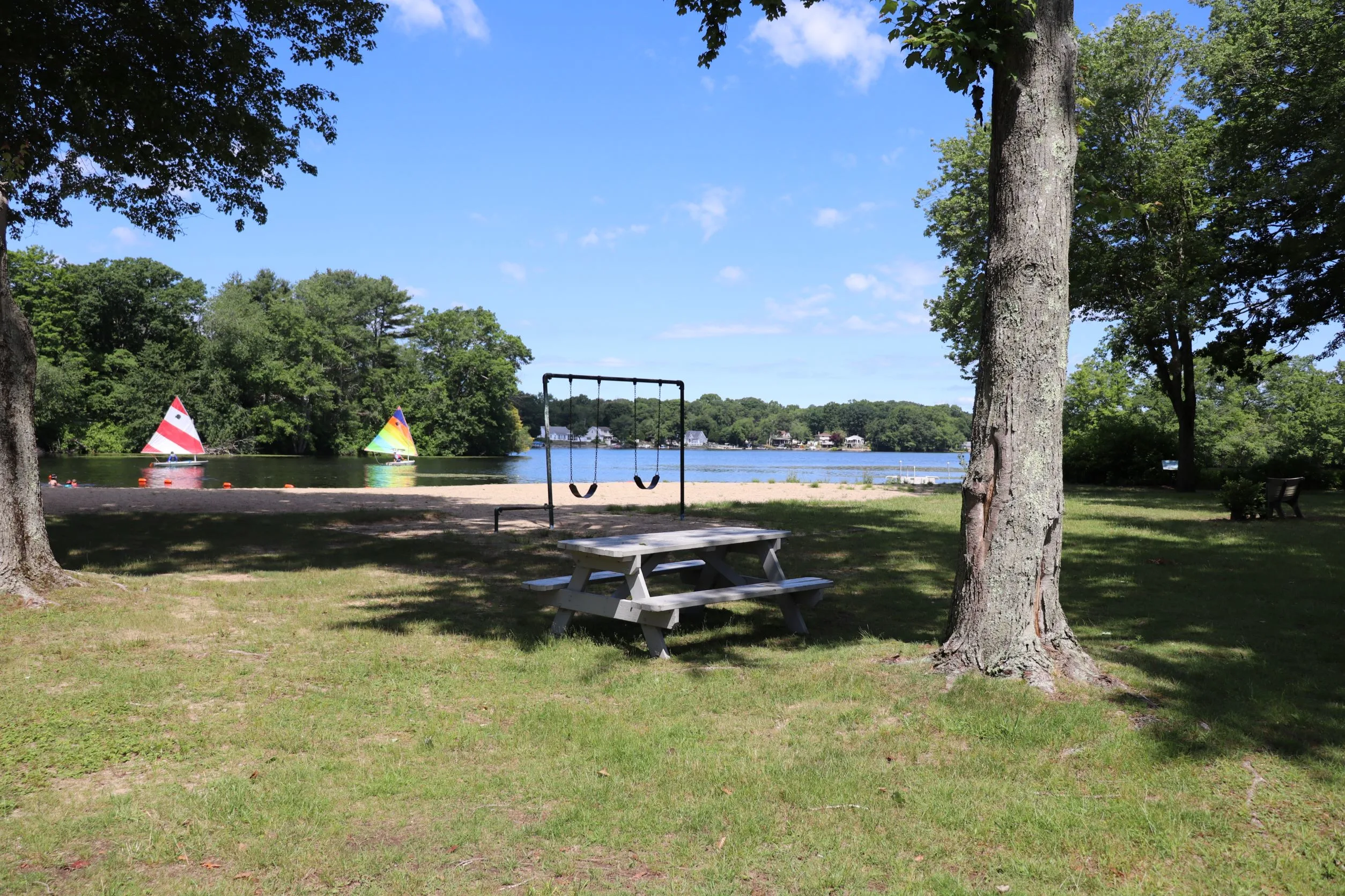 Image of picnic area and sail boats and swings in Haines Park in Old Lyme CT.