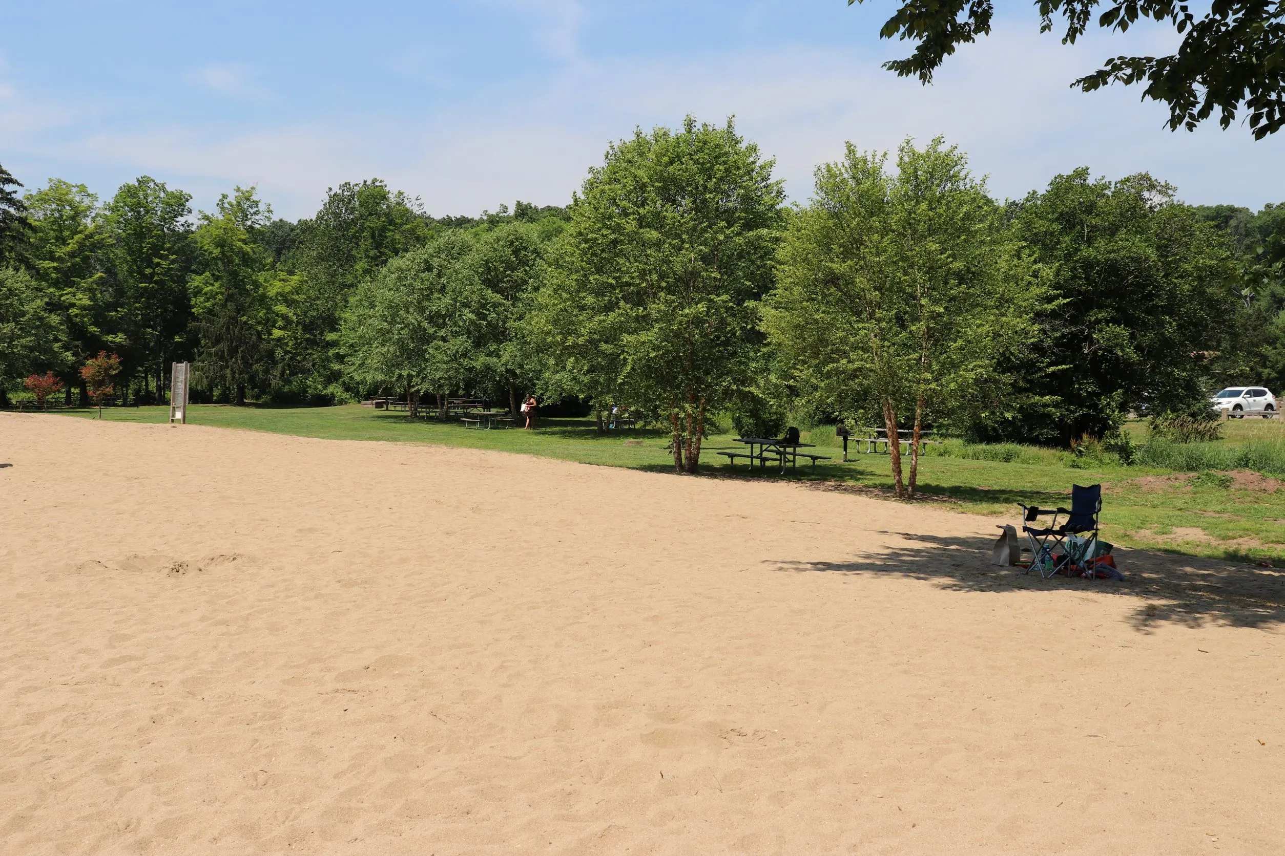 image of sand and picnic tables at swimming beach in wadsworth state park in middletown ct.