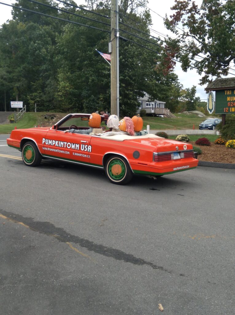 Imahe of orange classic car that reads pumpkintown usa in CT.