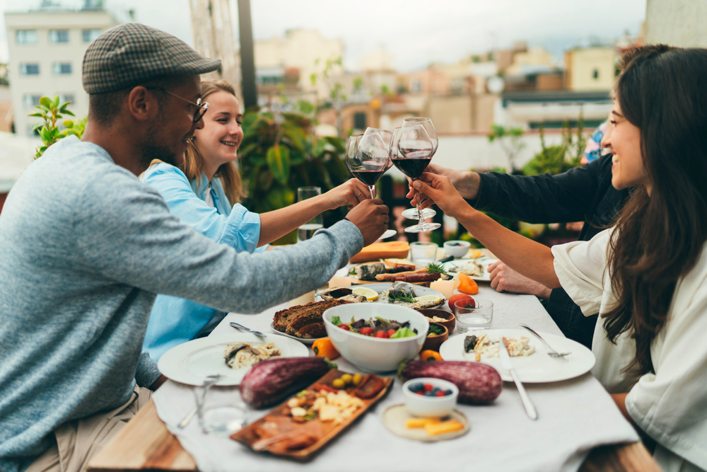 image of adults drinking wine and eating at one of the rooftop restaurants in CT.