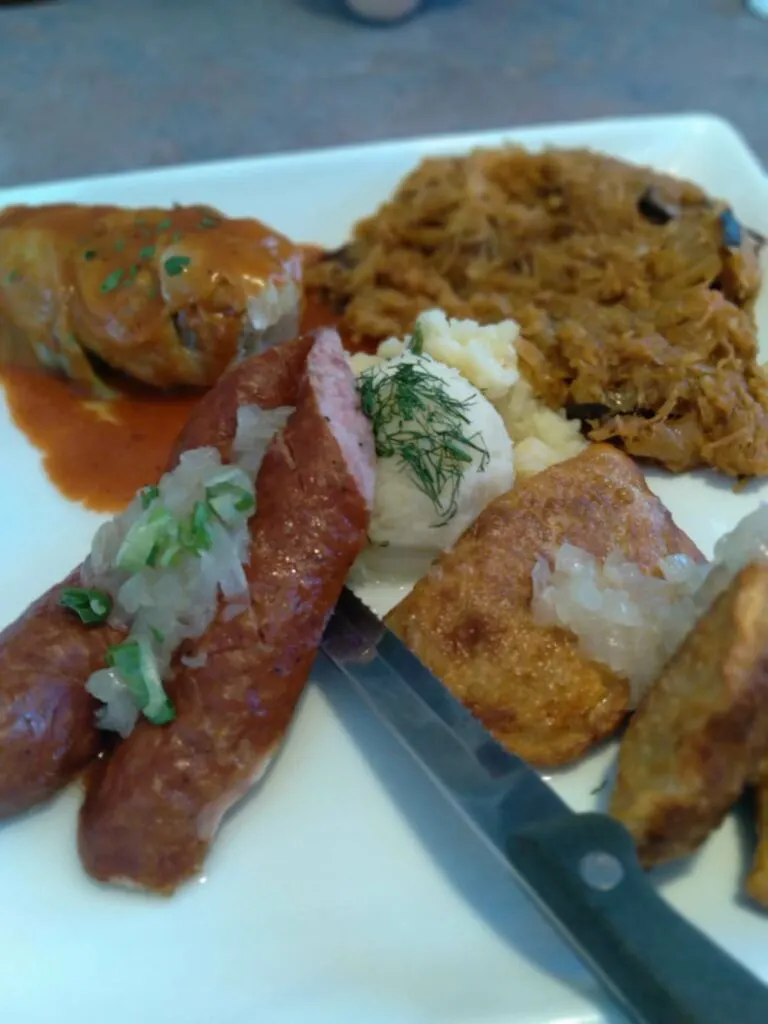 image of Polish meal of stuffed cabbage, kielbasa, and pierogies at Starpolska.